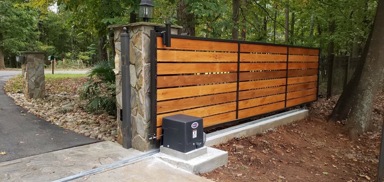 Automated residential sliding gate with wood panel design and gate operator installed in Venice, FL by Sarasota Gate & Access