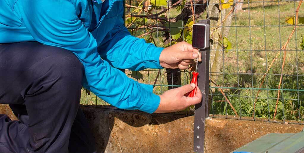 Technician inspects sensor of an automatic gate