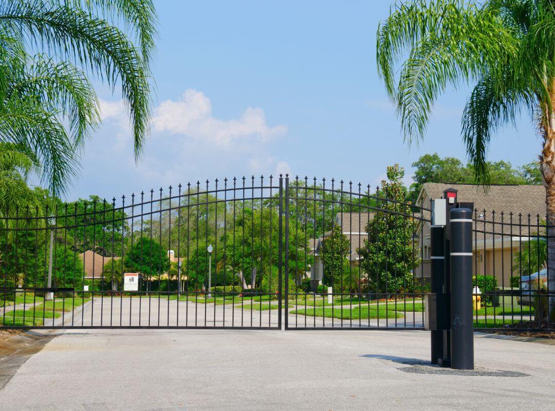 Automated ornamental iron dual swing gate with gate operator at a gated HOA community entry in Sarasota, FL