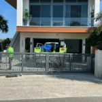 Sarasota Gate & Access technician installing a modern aluminum sliding gate at a luxury coastal home in Sarasota, FL