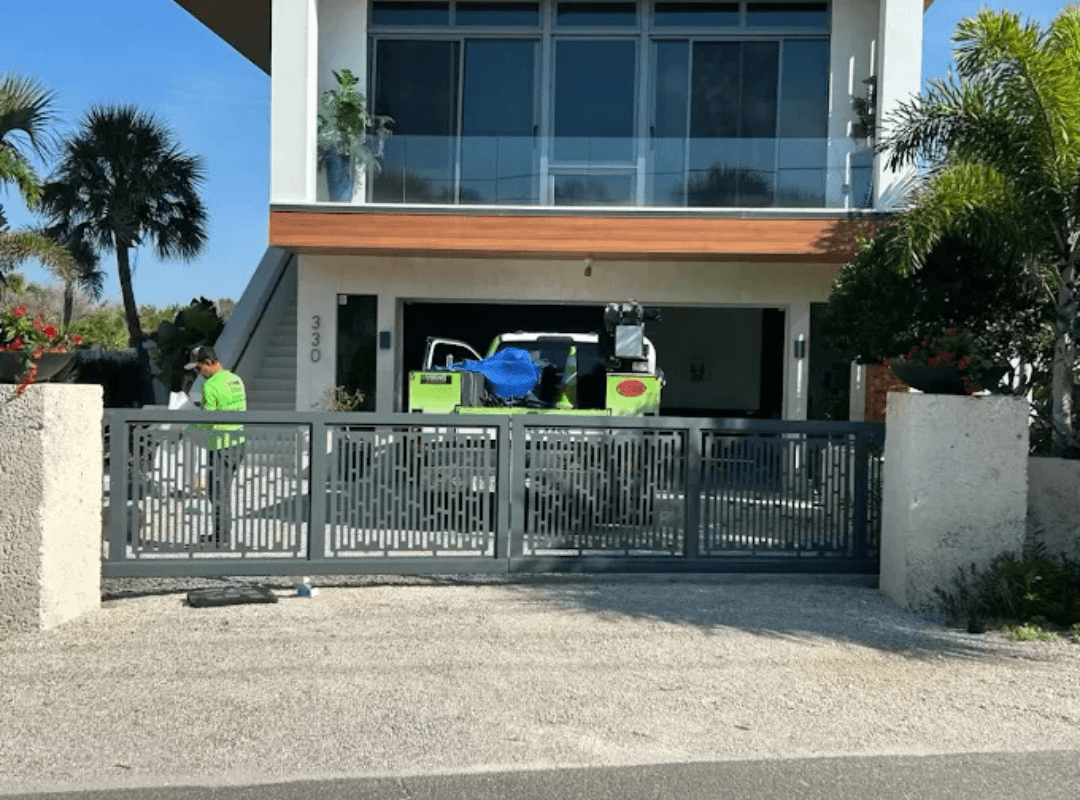 Sarasota Gate & Access technician installing a modern aluminum sliding gate at a luxury coastal home in Sarasota, FL