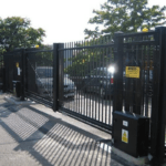 Heavy-duty commercial automated sliding gate with gate operator and caution signage installed at a commercial property — the type of commercial gate installation Sarasota Gate & Access delivers for business owners and property managers