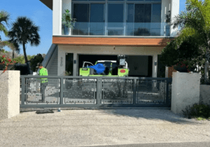 Sarasota Gate & Access technician installing a modern aluminum sliding gate at a luxury coastal home in Sarasota, FL