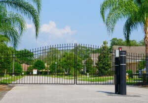 Automated ornamental iron dual swing gate with gate operator at a gated HOA community entry in Sarasota, FL