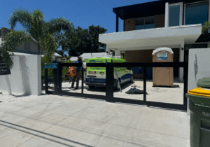 Sarasota Gate & Access technicians installing a modern aluminum sliding driveway gate at a luxury residential property in Fort Myers, FL